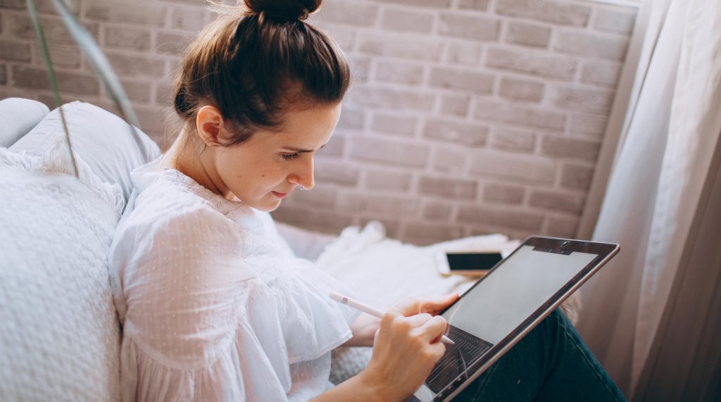 woman is creating a digital artwork with a tablet