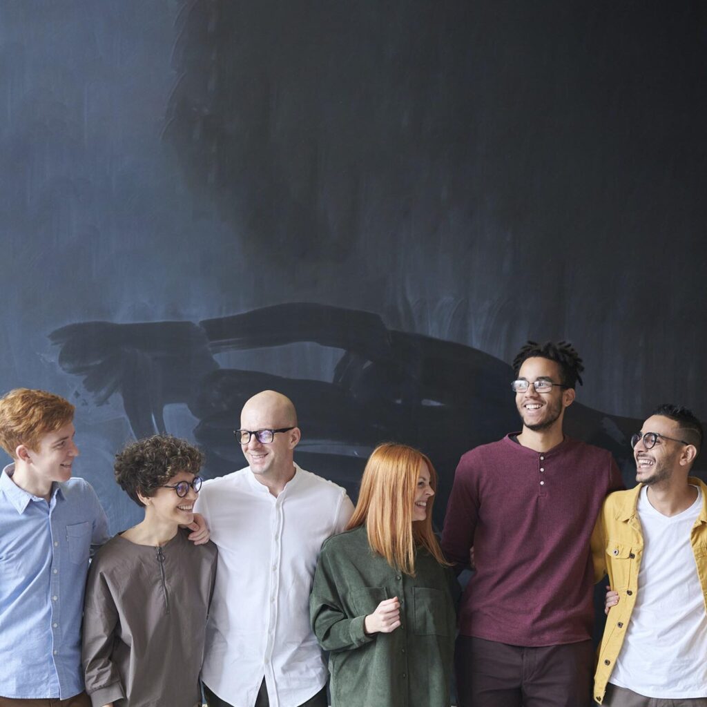 profesores sonriendo juntos junto a una pizarra